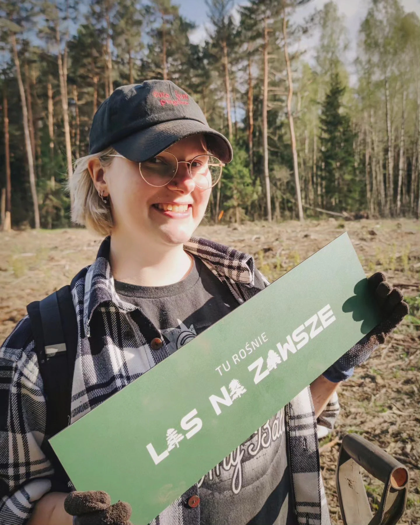 Klara Keczyńska sadzi młode drzewo w lesie, a na drugim zdjęciu trzyma tabliczkę „Las na zawsze”.