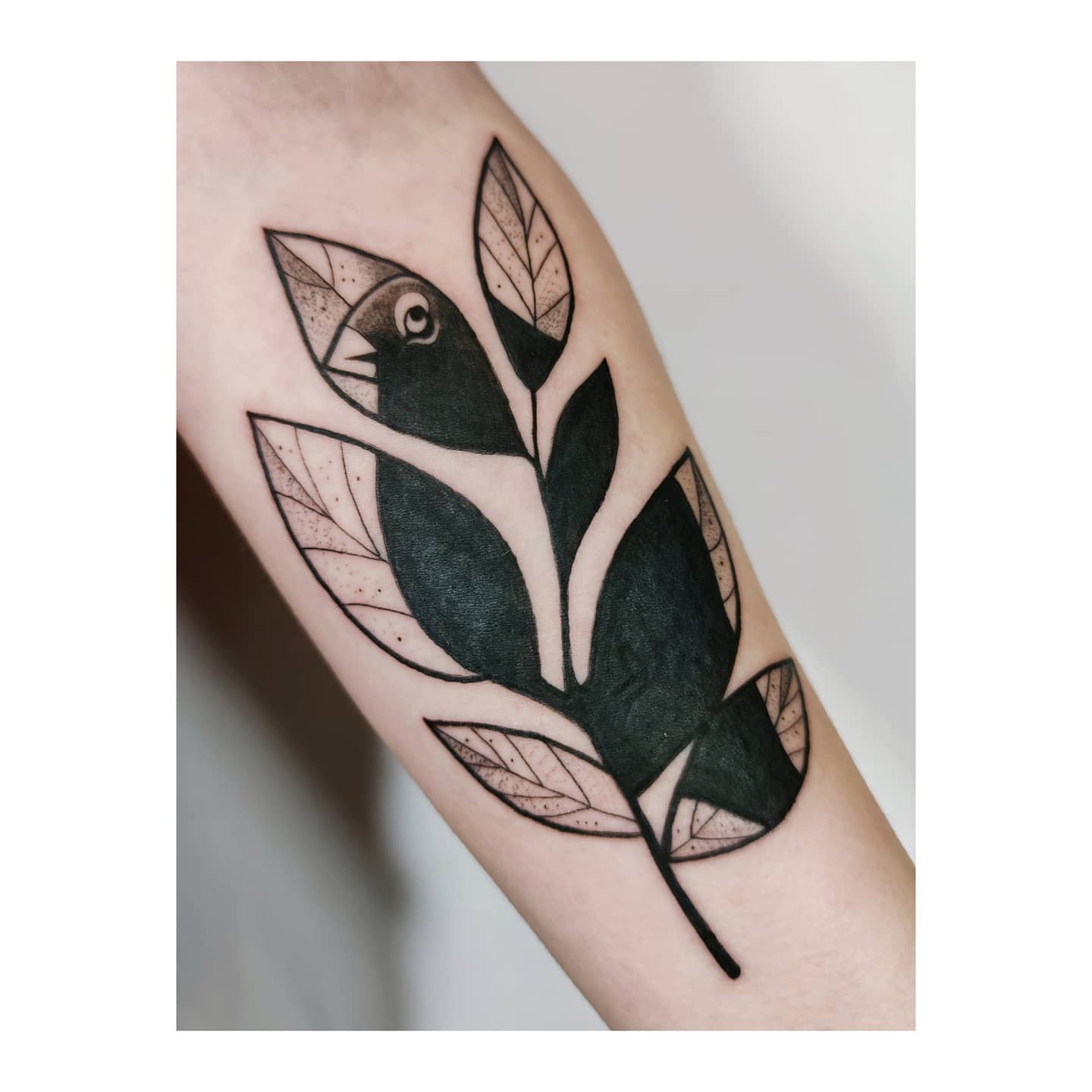 Czarny ptak z liści – blackwork tattoo
