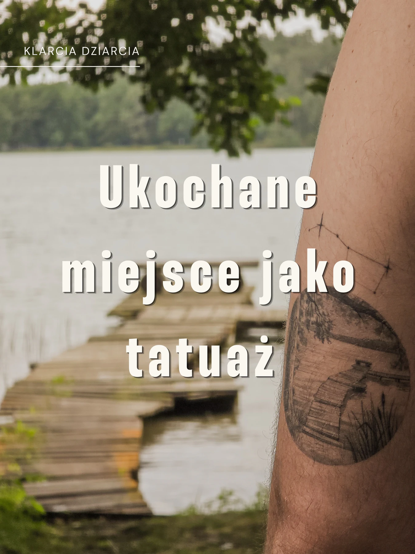 Tatuaż na ramieniu przedstawiający drewniany pomost nad jeziorem, otoczony drzewami i roślinnością; w tle widoczny jest podobny pomost nad wodą.